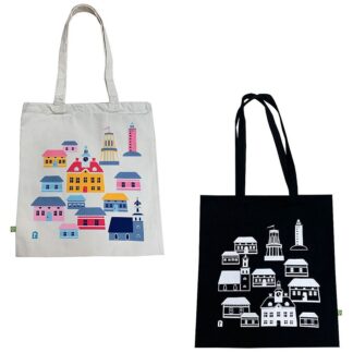 The picture shows two canvas bags. The white bag has Rauma's most famous buildings printed in color, and the black bag has the same print in white.